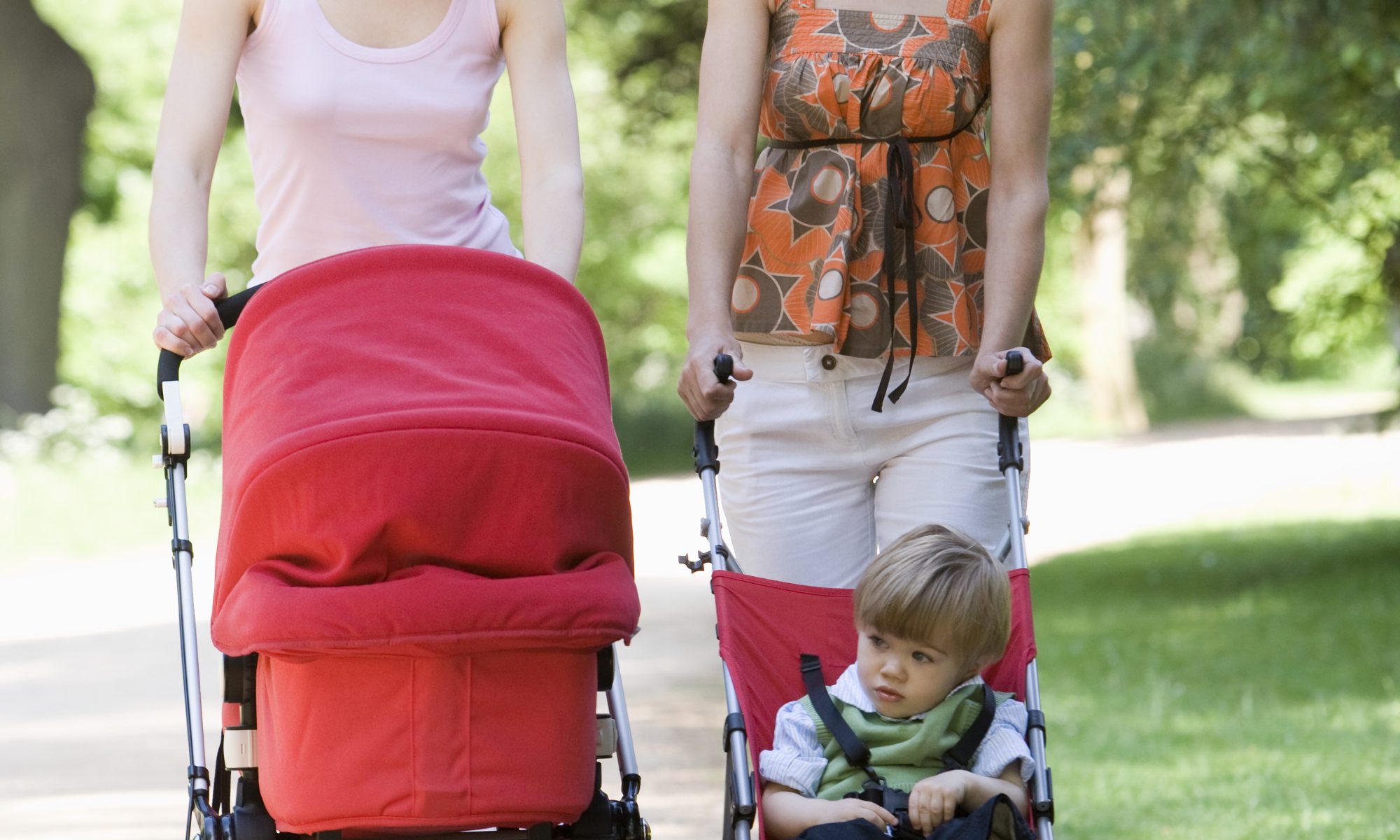 mother pushing baby in strollers